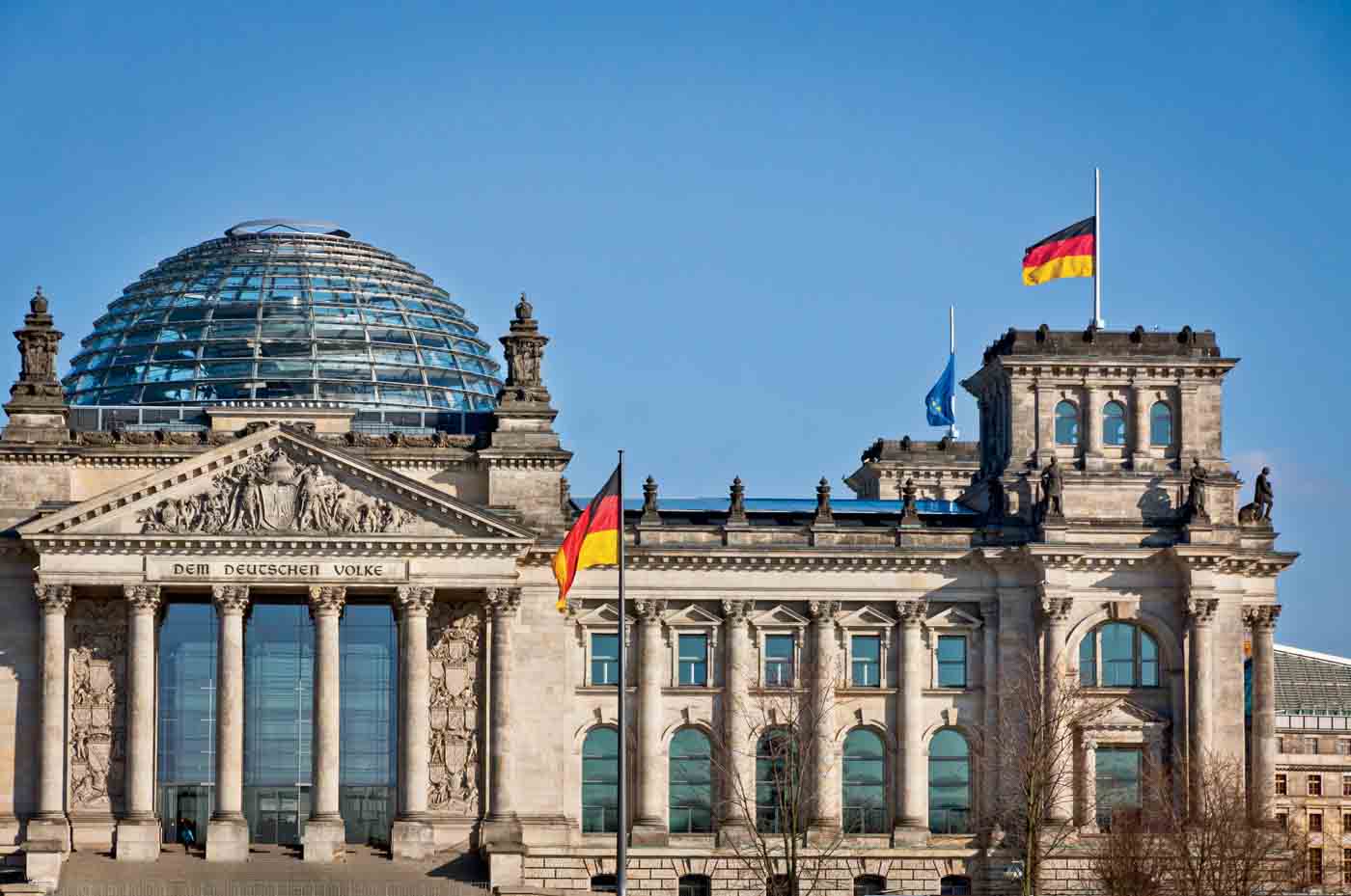 German National Flags Waving In Front Of German Parliament Buildi