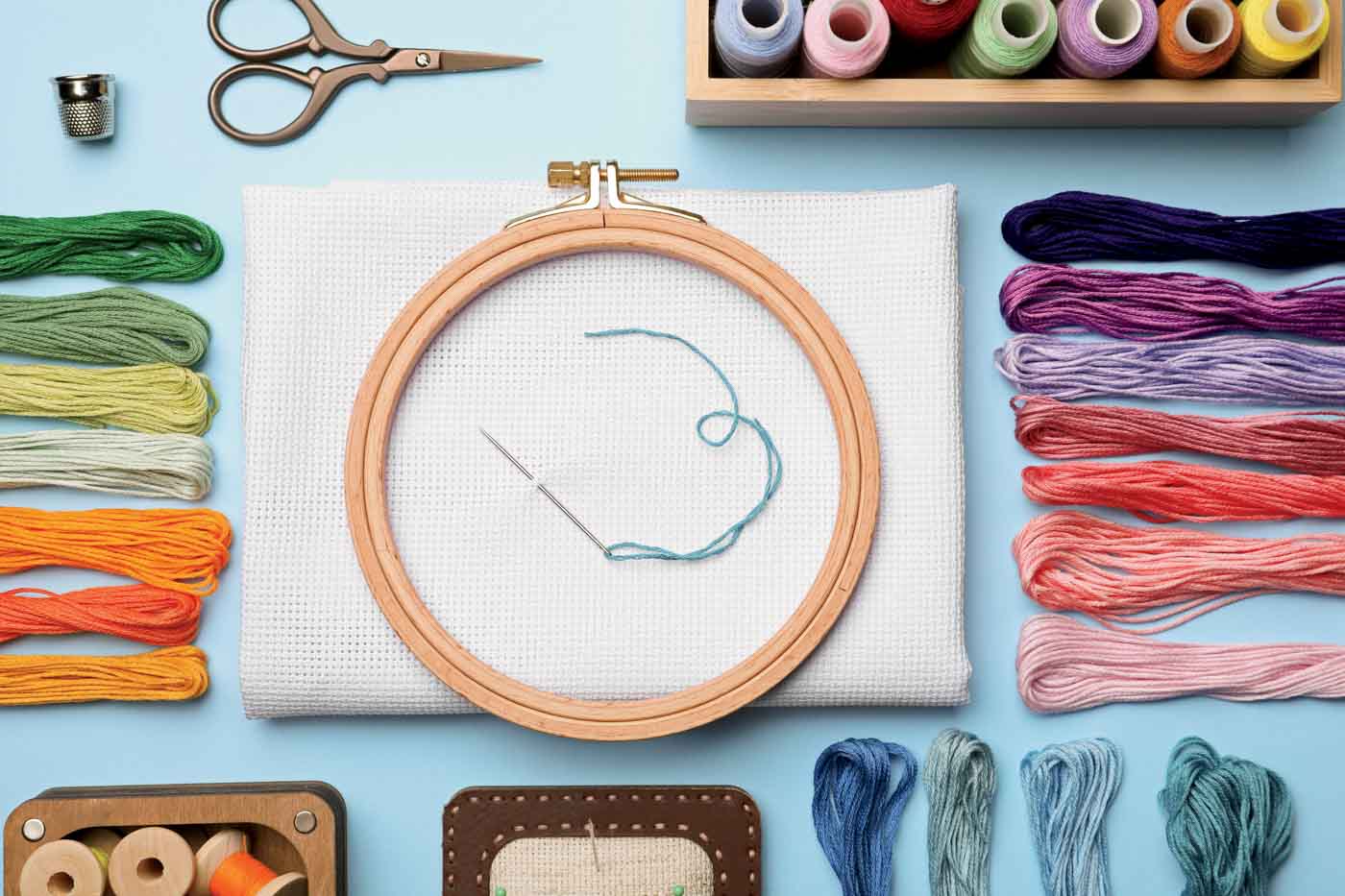 Flat Lay Composition With Embroidery Accessories On Light Blue Background